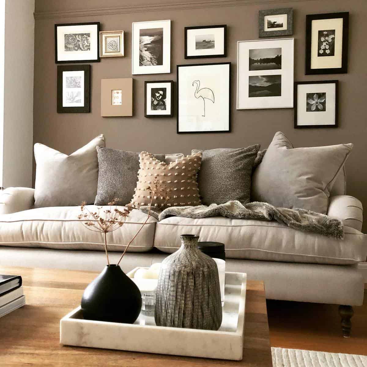 brown accent wall framed photos gray couch
