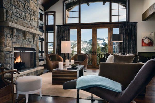 alpine style living room with stone fireplace and mountain views