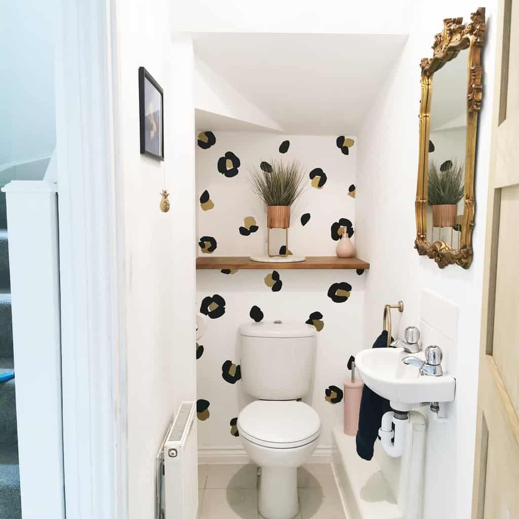 print wallpaper toilet with gold framed wall mirror 
