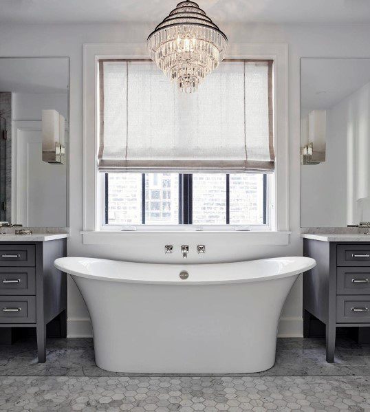 large white freestanding tub with chandelier