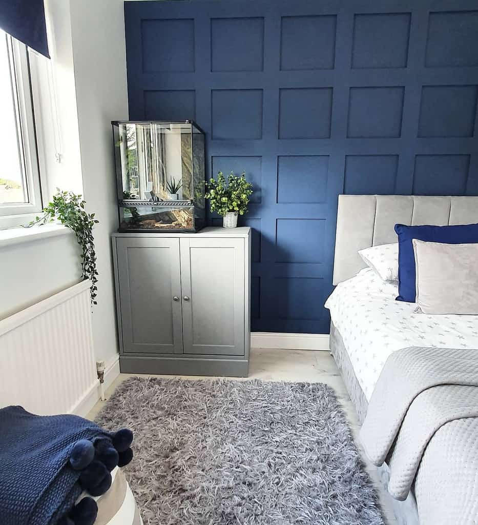 bedroom blue wall paneling gray cabinet and bed