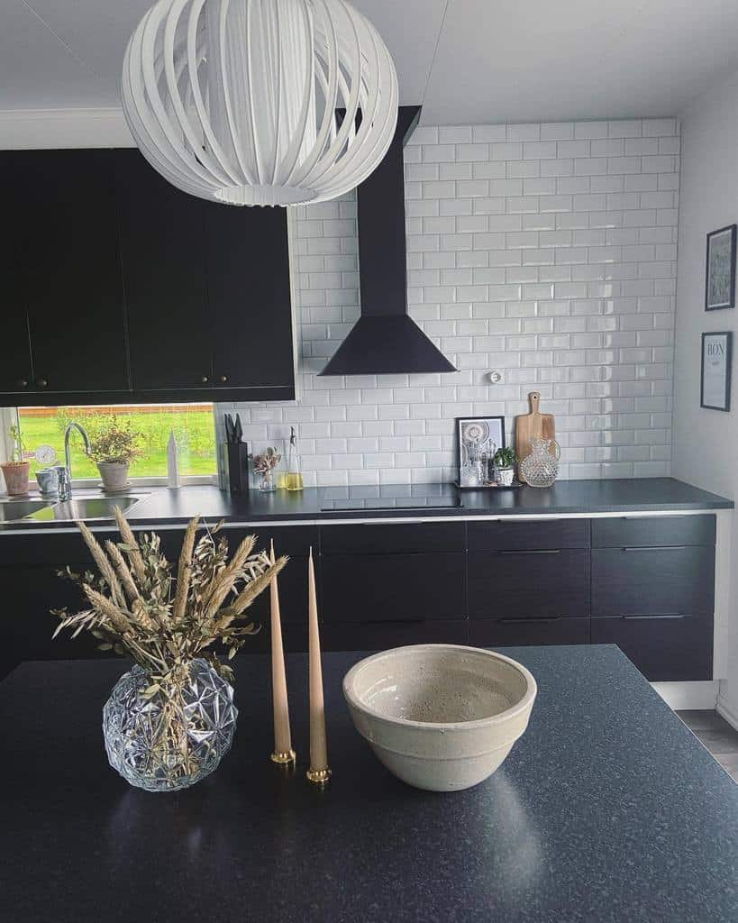 modern kitchen with black cabinets and white subway tile splashback 