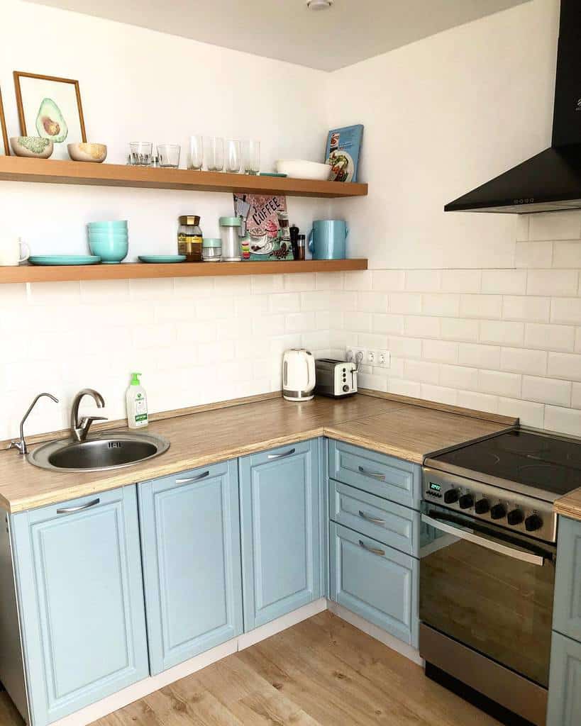 country kitchen with blue cabinets wood countertops and wall shelves 