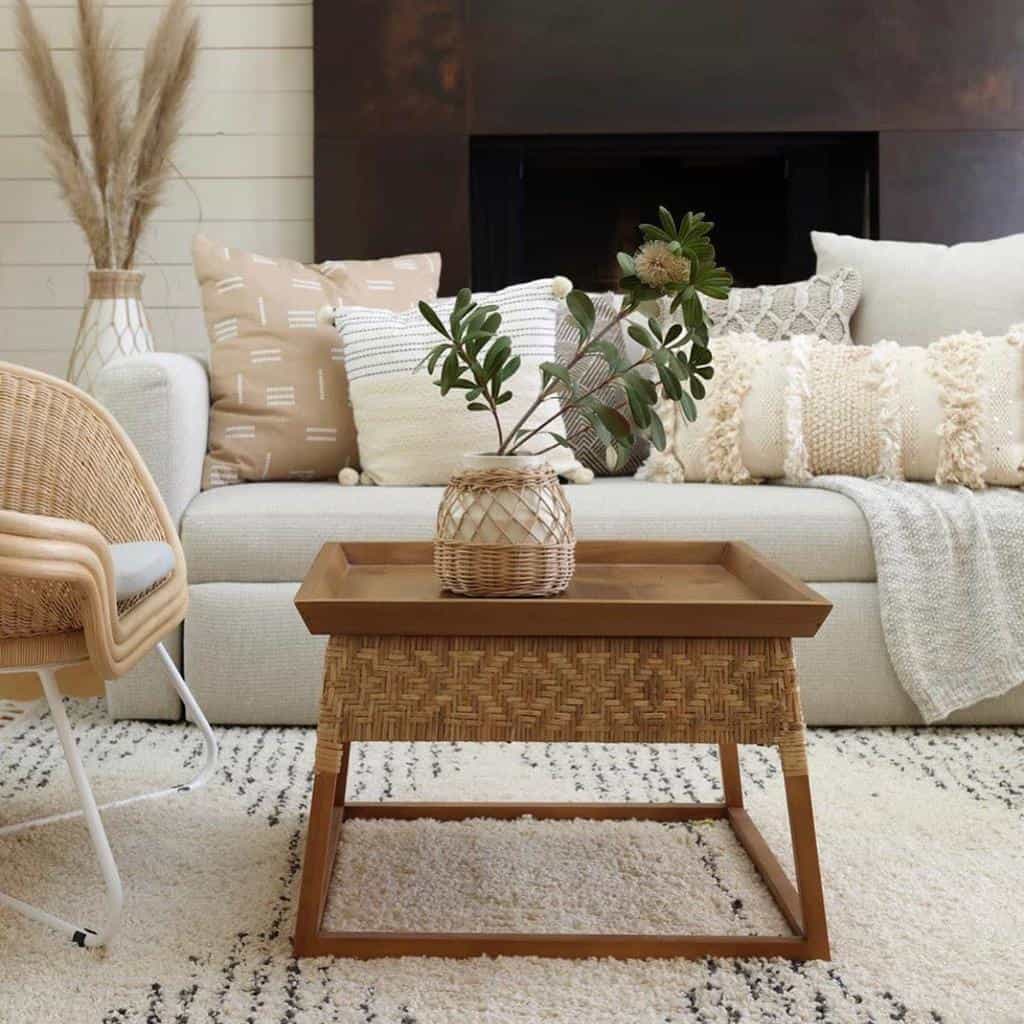 country living room fireplace white sofa with pillows wicker chair and table 