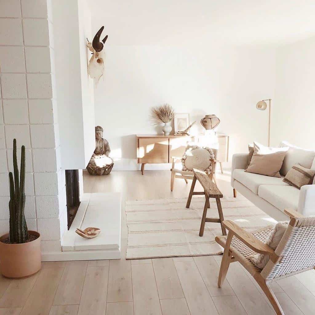 minimalist boho living room white sofa wood bench two wood cane chairs fireplace 