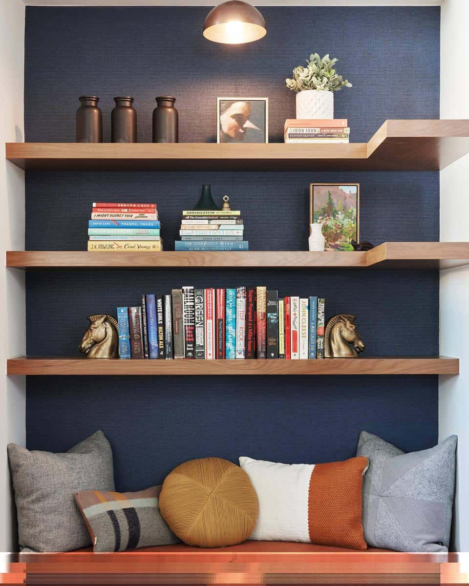 blue accent wall wood bookshelves and metal bench seat
