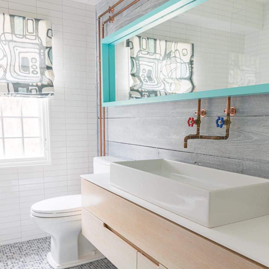 simple boys bathroom white sink blue edge wall mirror copper faucets 