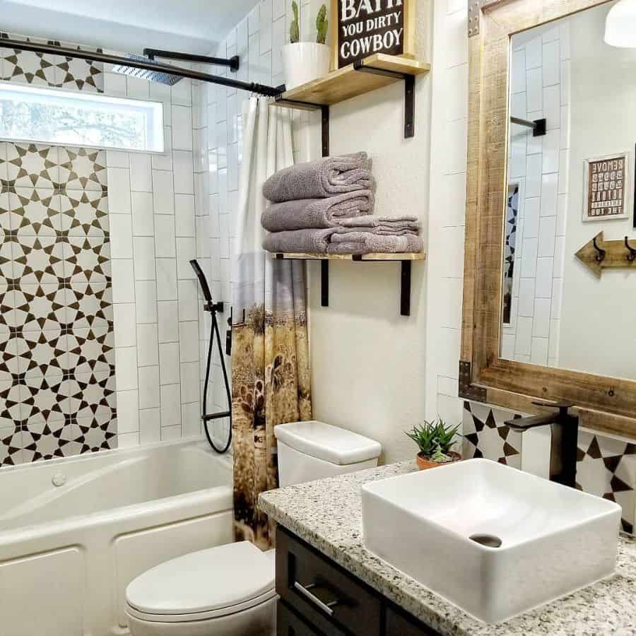 country style bathroom tile shower wood rimmed mirror wall shelves with towels 
