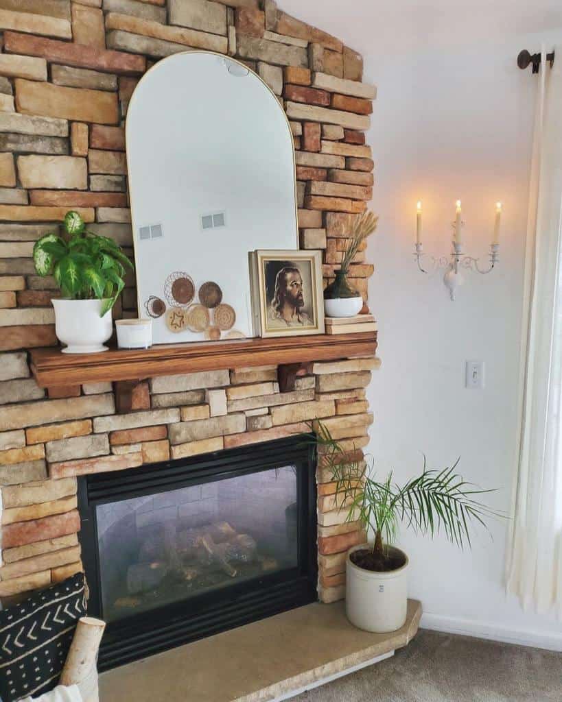 brick stone fireplace mantle with mirror plants and jesus picture wall candles 