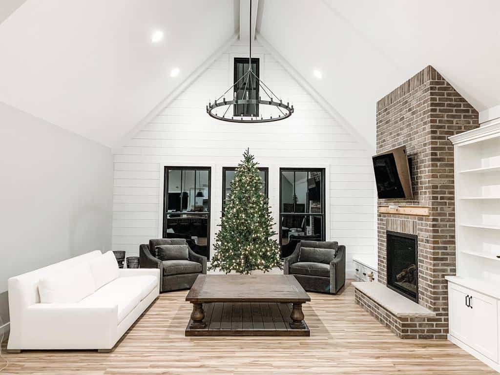 high ceiling living room brick fireplace white shiplap wall white couch christmas tree