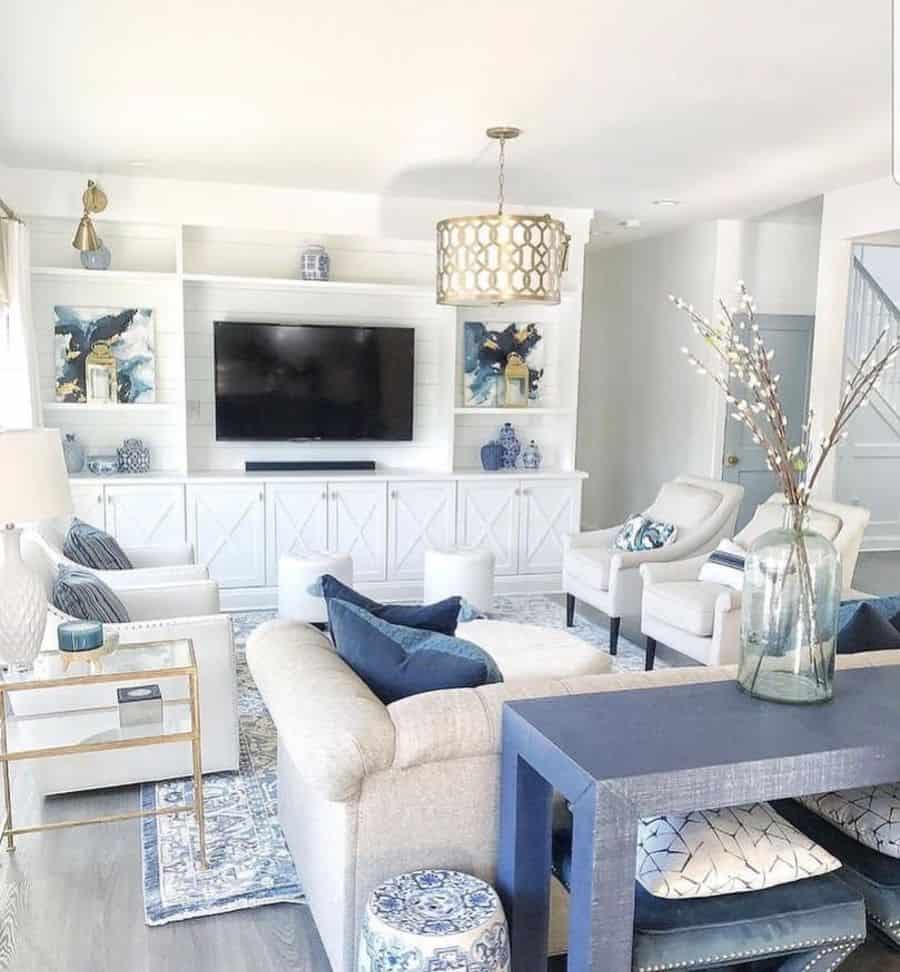 white living room cabinets and sofa with gold accents and blue pillows table 