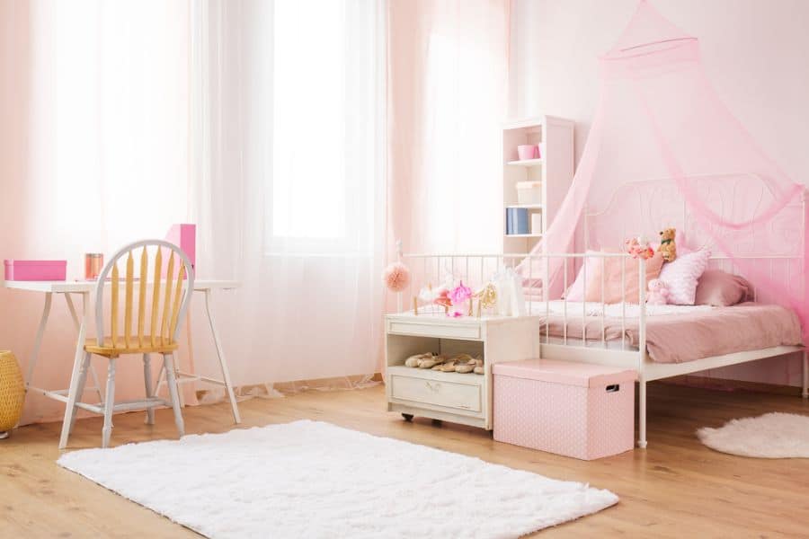 pink theme girls bedroom canopy bed small desk white floor rug 