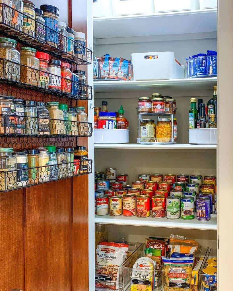 well stocked kitchen pantry with wire spice rack on door 