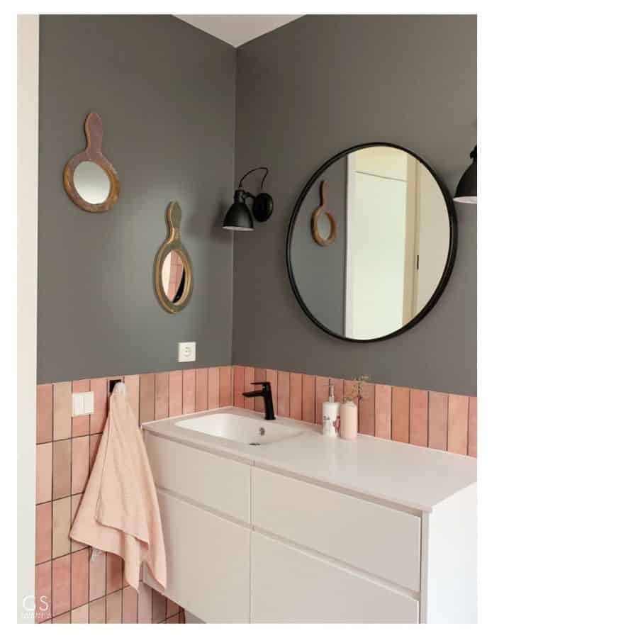 two tone gray wall pink tiles bathroom white vanity black rim wall mirror 
