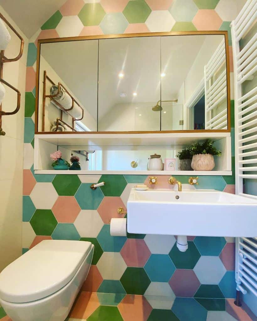 colorful tile feature wall bathroom floating white sink gold faucet recessed shelving 