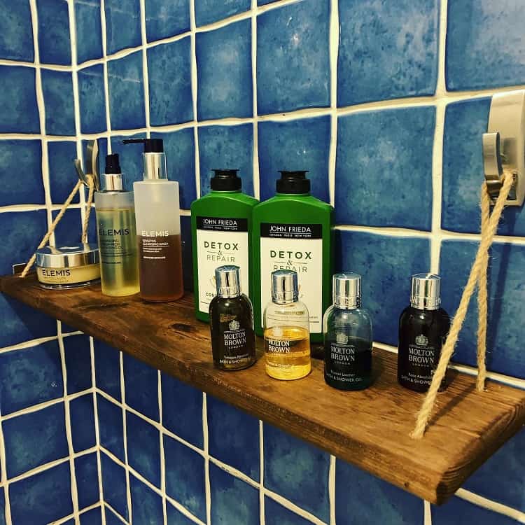 wood shelf in shower with men's beauty products
