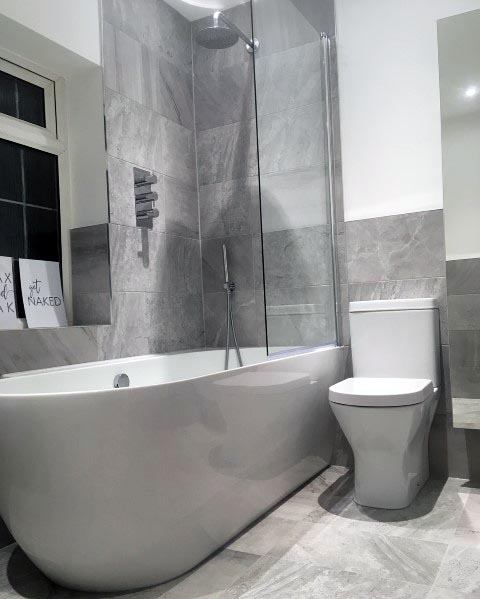 minimalist gray tile small master bathroom with white tub 