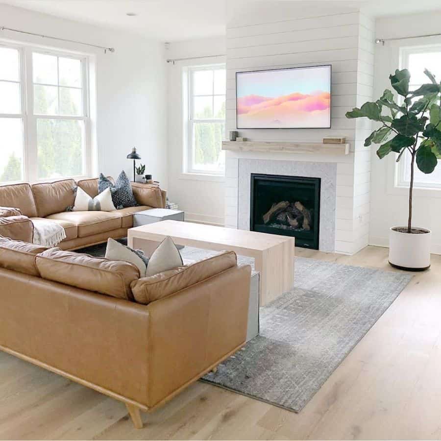 white living room with fireplace and tan leather sofa 