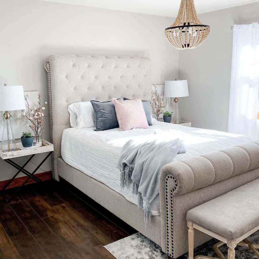 cozy small master bedroom with gray bed and chandelier