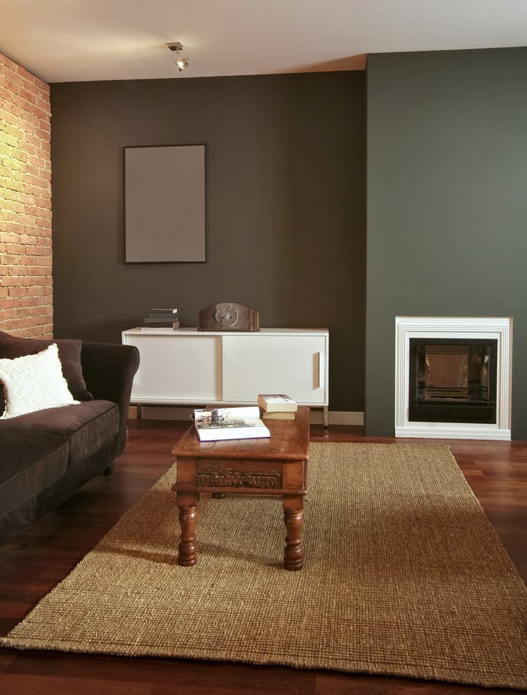 exposed brick gray wall living room fireplace white cupboard