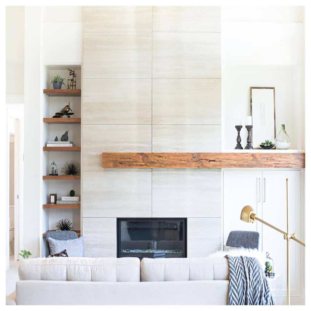 modern white stone fireplace wall wood mantle candlesticks recessed wall shelf gold floor lamp 
