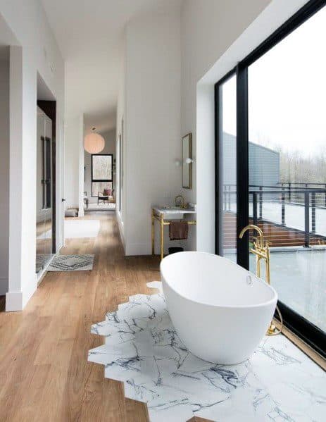 white bathtub marble tiles window view