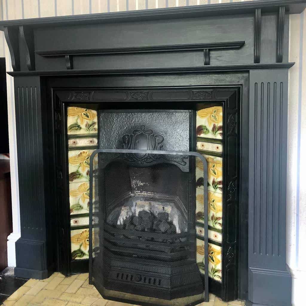 black fireplace wall with floral tiles 