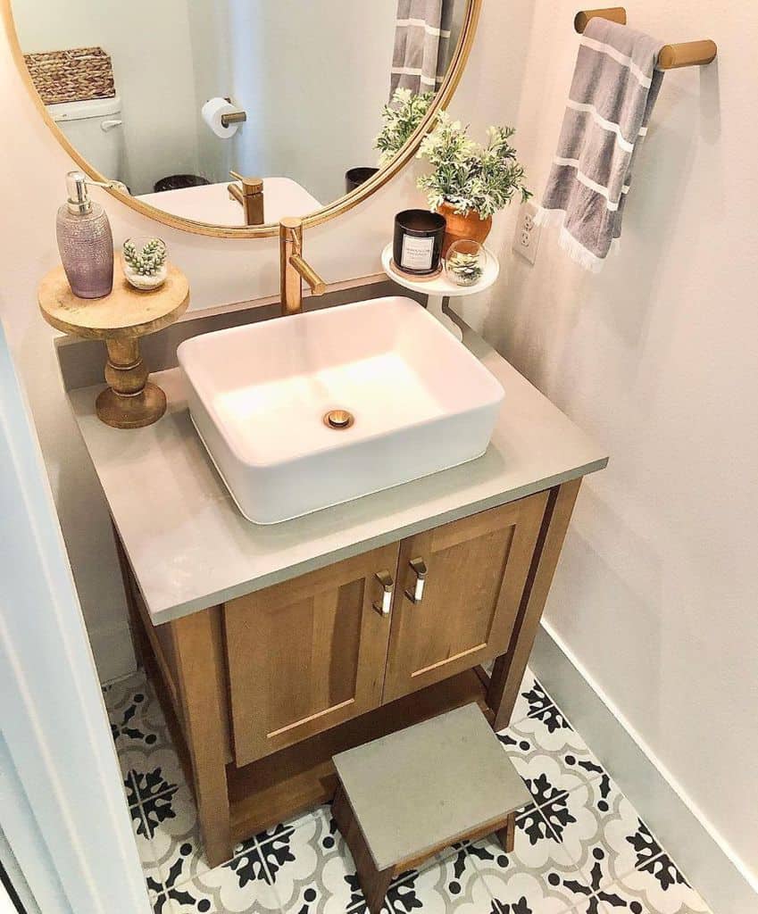 modern bathroom small white sink gold accents mirror pattern tile floor