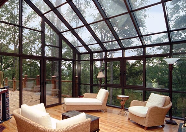 large full glass wall and ceiling sunroom wood floorboards