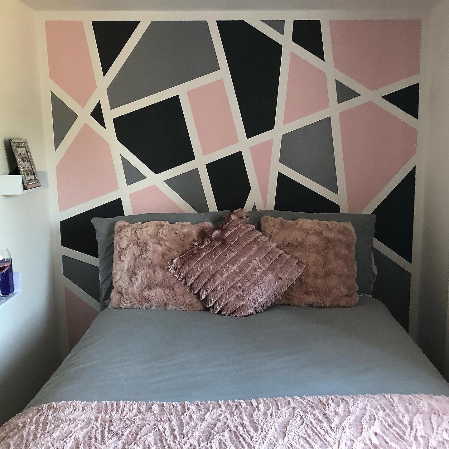 black gray and pink geometric accent wall in bedroom 