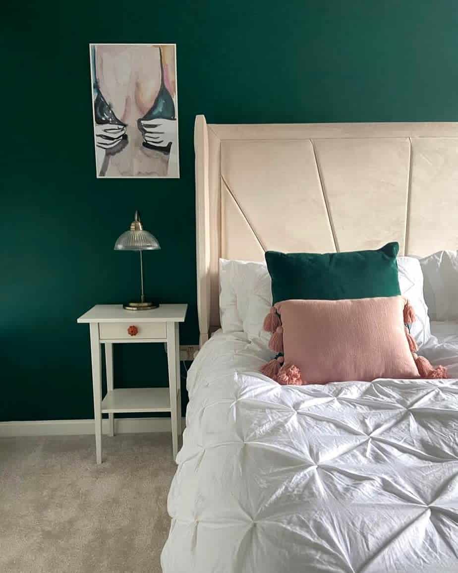 dark green accent wall cream headrest platform bed white bedside table woman undressing wall art