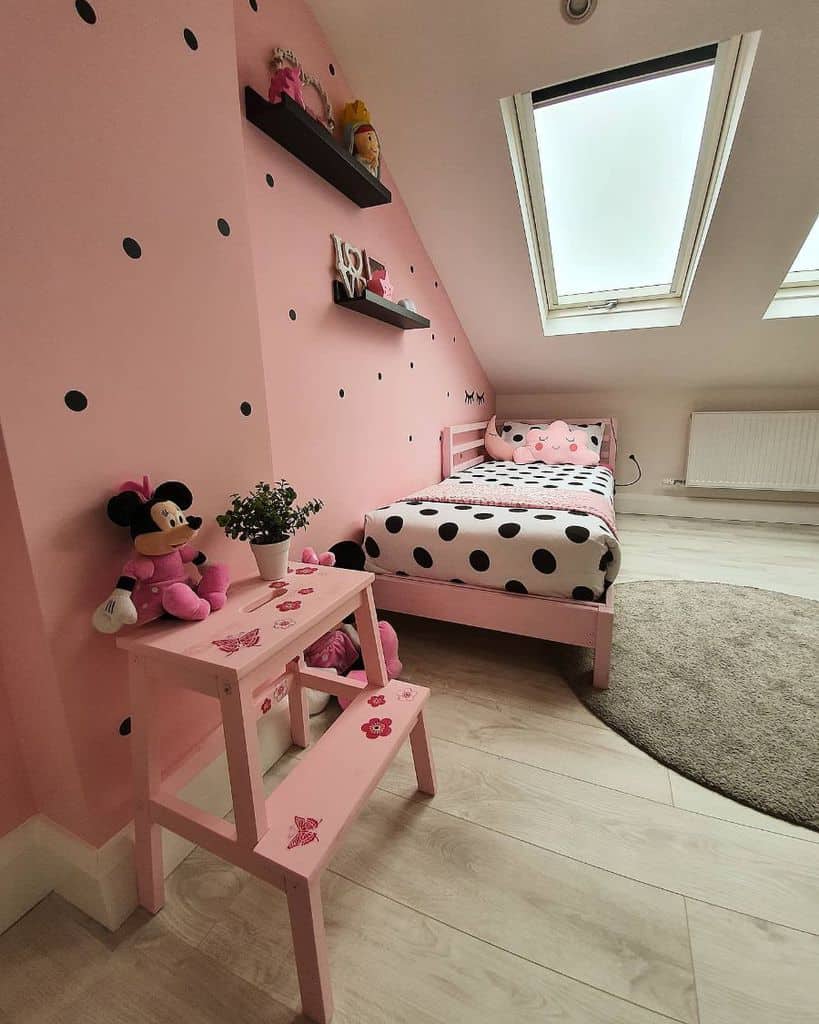 girls attic bedroom with pink accent wall
