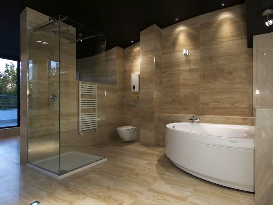 large luxury bathroom with glass shower and white spa 