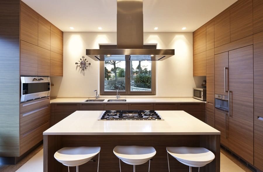 modern brown kitchen with granite island and white stools 