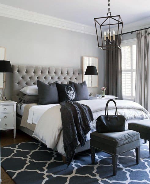 gray small master bedroom with chandelier