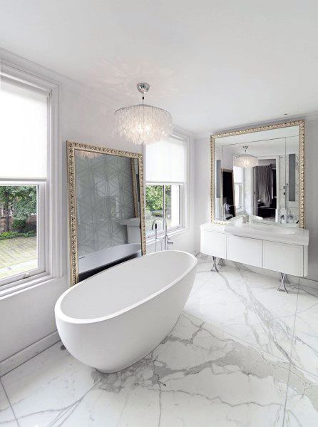 luxury bathroom marble floor gold trim mirrors freestanding tub chandelier