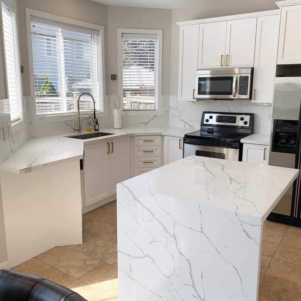 small white kitchen with island and marble countertops 