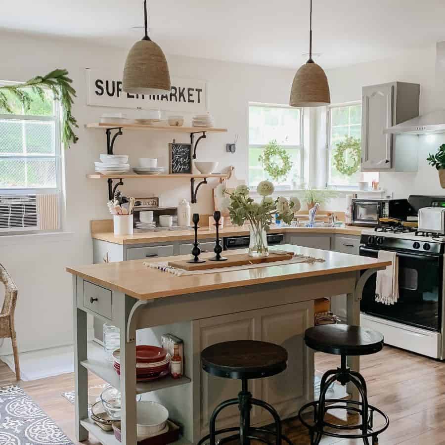 country kitchen green island cabinet wood countertop black stools 