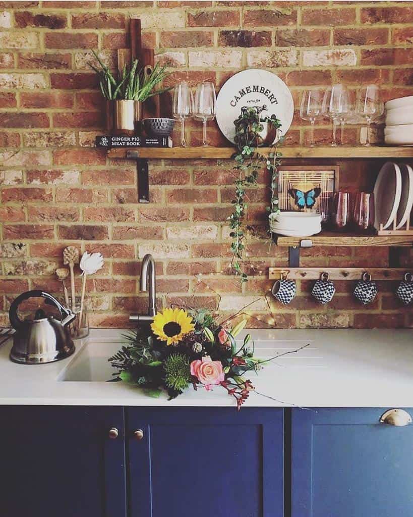 brick wall kitchen wood wall shelves blue cabinets 