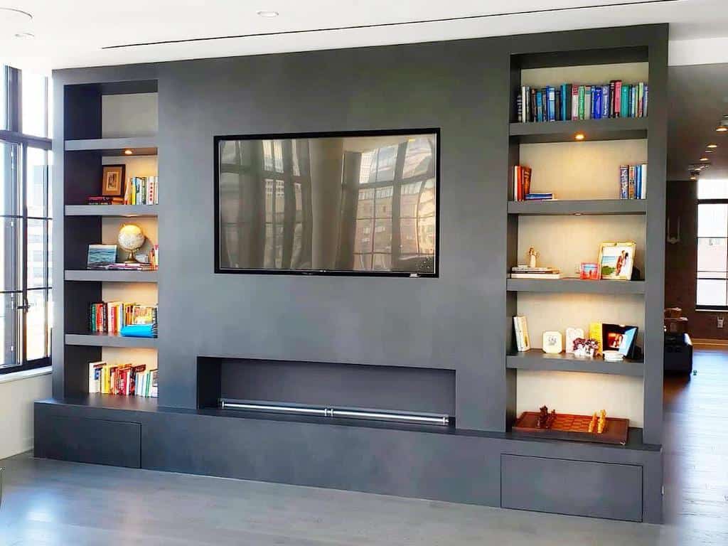 large grey shelving unit with electric fireplace and wall mounted tv