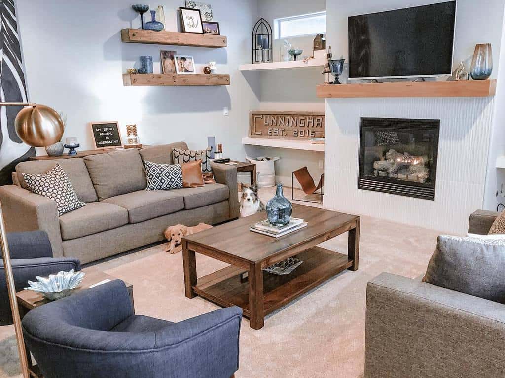 country style living room with fireplace wood coffee table gray sofa blue accent chairs 