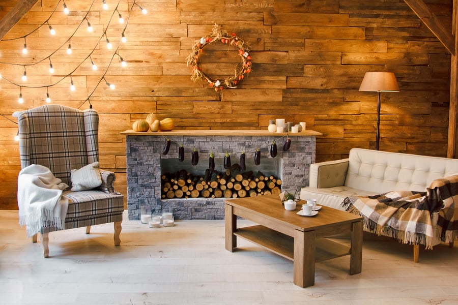 logs stacked in stone fireplace lounge hanging lights wood coffee table 