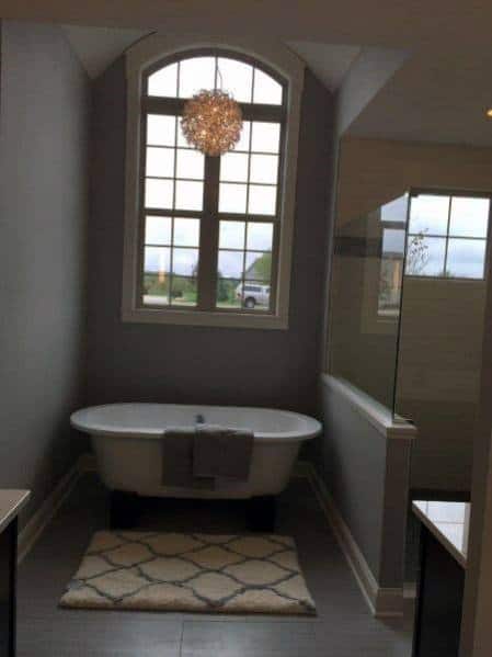 luxury home master bathroom with chandelier above bathtub