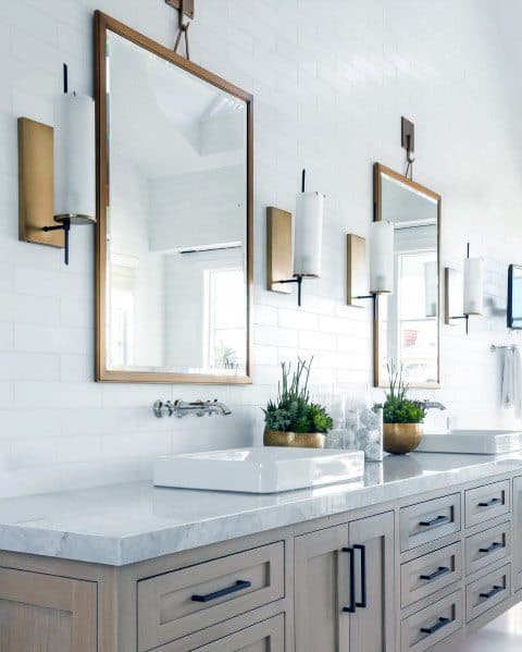 wood vanity master bathroom with gold framed mirrors