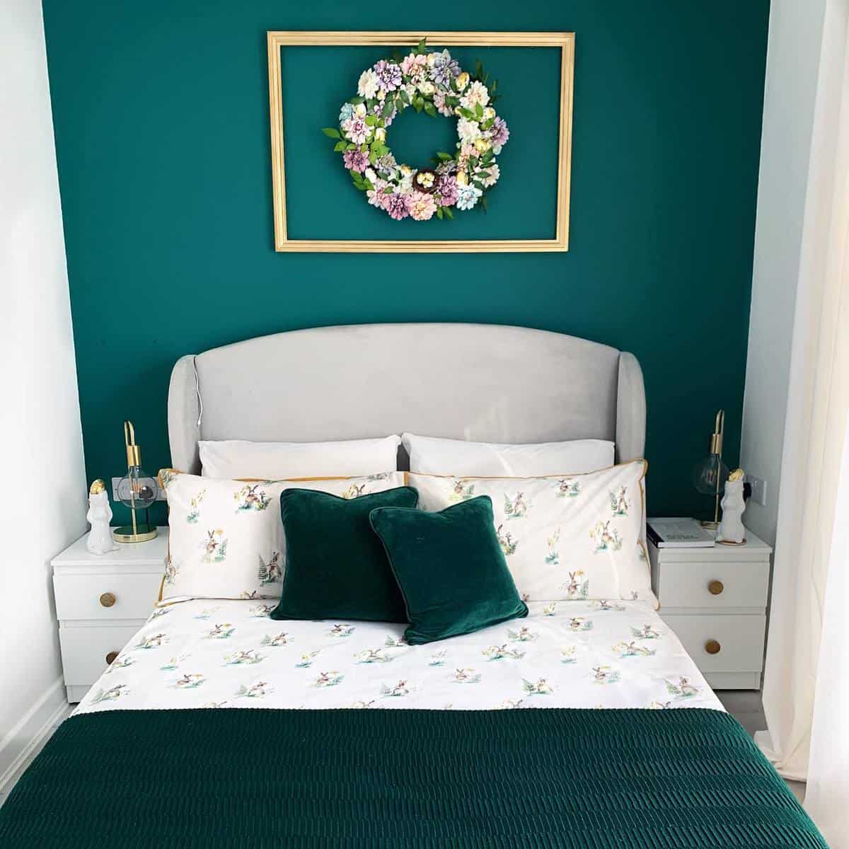 small green accent wall bedroom gray headboard gold framed wreath 