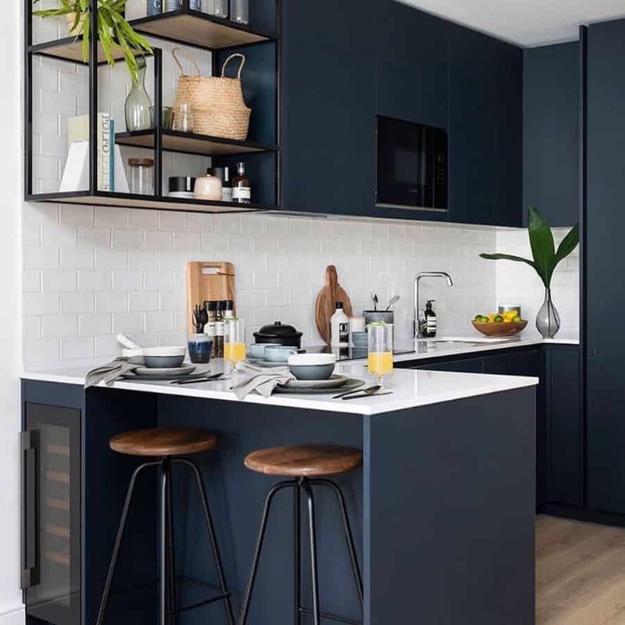 navy blue kitchen white brick backsplash two metal and wood stools 