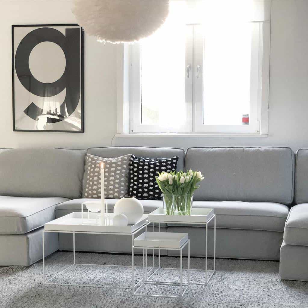 minimalist living room gray sofa three different sized white coffee tables 