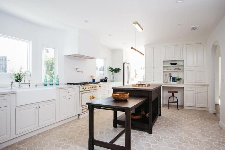 modern french country kitchen gold accents wood island bench hexagonal tile floor 