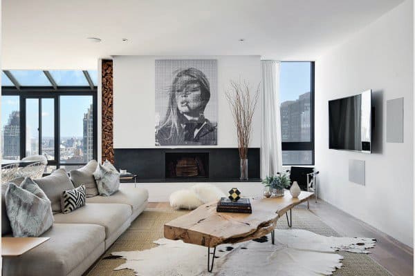 luxury apartment living room gray sofa wood log coffee table fireplace wall mounted tv 