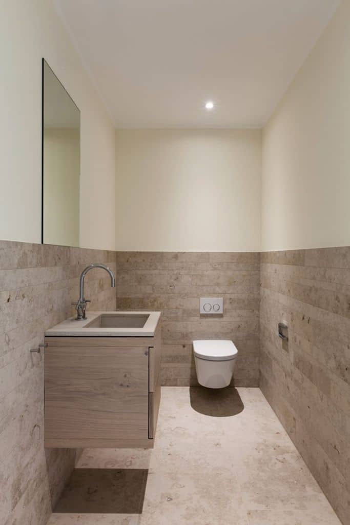 small powder room with tile wall and floating toilet 